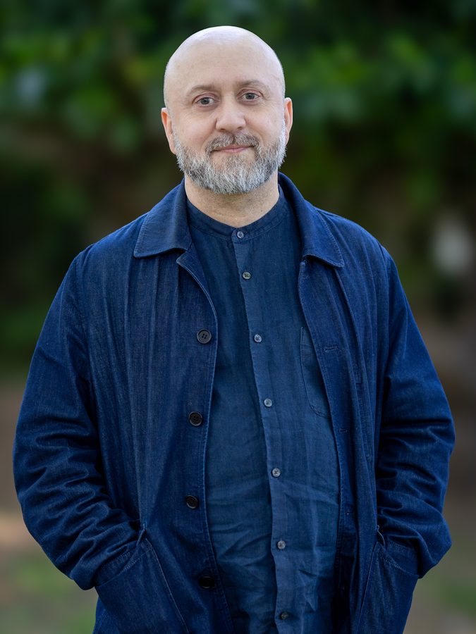 Damian Dudkiewicz in a denim jacket, standing outdoors